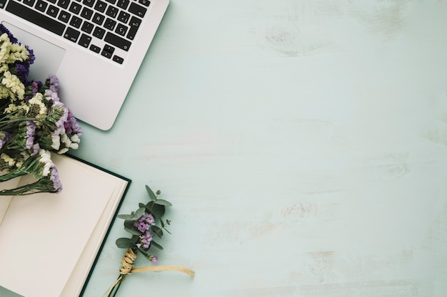 Flowers and notebook near laptop