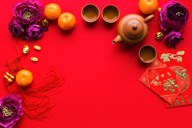 Flowers and tangerines near tea ceremony supplies