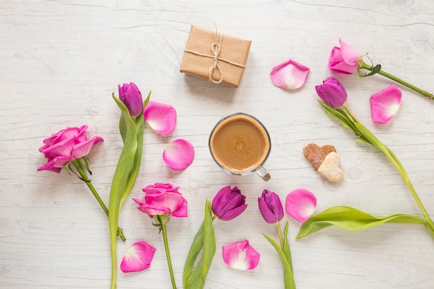 Free photo flowers with gift box and coffee on table