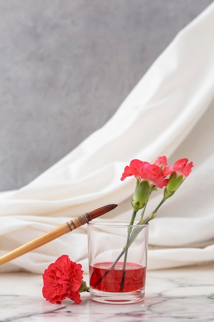 Flowers with glass beside