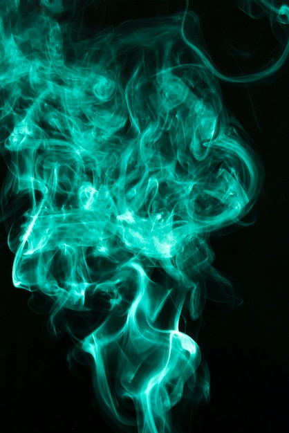 Free photo fluffy puffs of green smoke and fog on black background