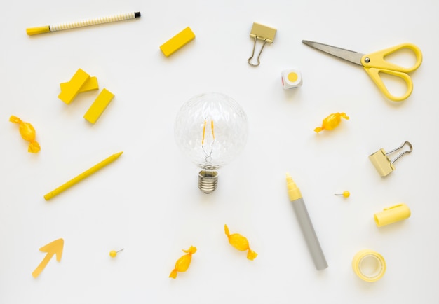 Free Photo fluorescent bulb surrounded by various stationeries and candies