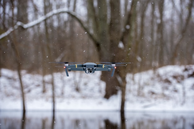 Free photo flying black drone during winter