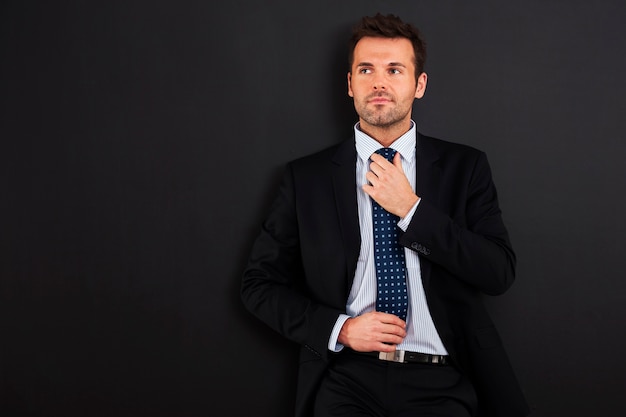 Free photo focus businessman wearing tie against blackboard