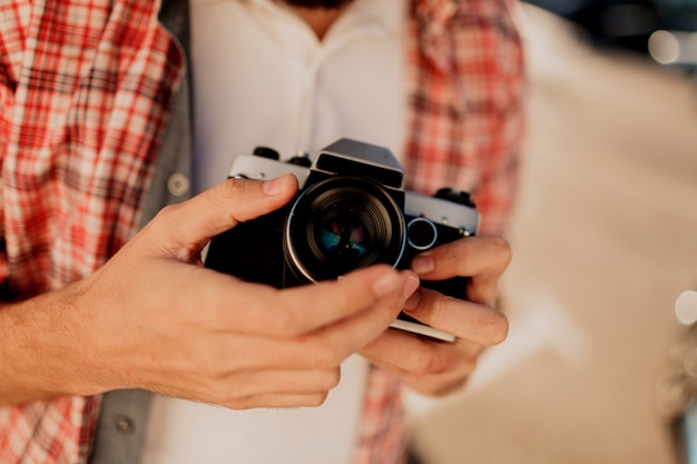 Free photo focus on camera. details. man  holding  film camera , making photos