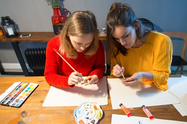 Free photo focused art school students learning painting