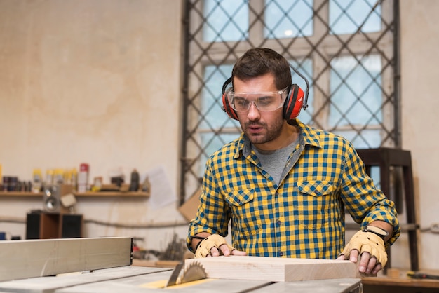 Free photo focused carpenter at work with wooden plank