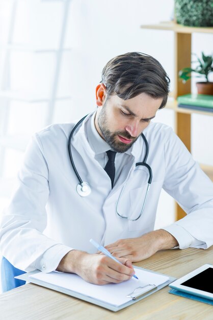 Focused doctor making notes in office