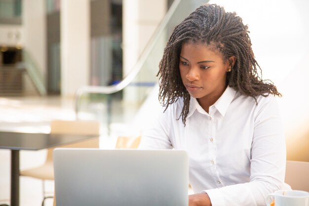 Focused female employee working in cafe