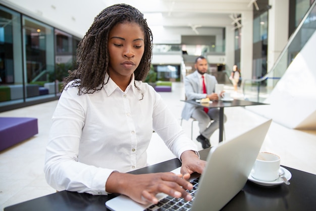 Focused female manager working on laptop