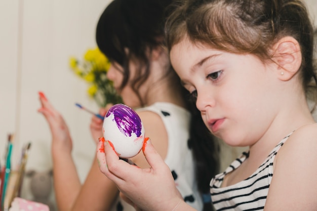 Free photo focused girl painting egg