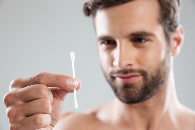 Focused man looking at ear stick