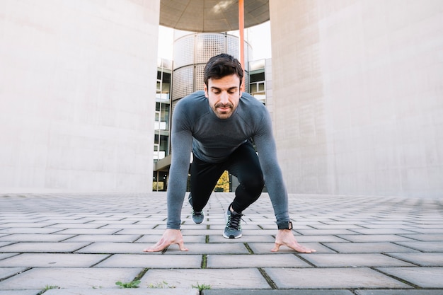 Focused man lunging on street