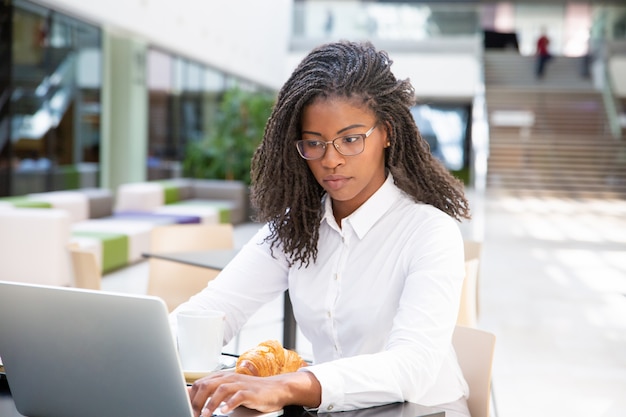 Focused successful professional having breakfast in cafe