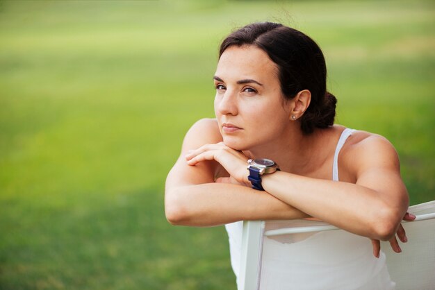 Focused woman sitting on chair looking away