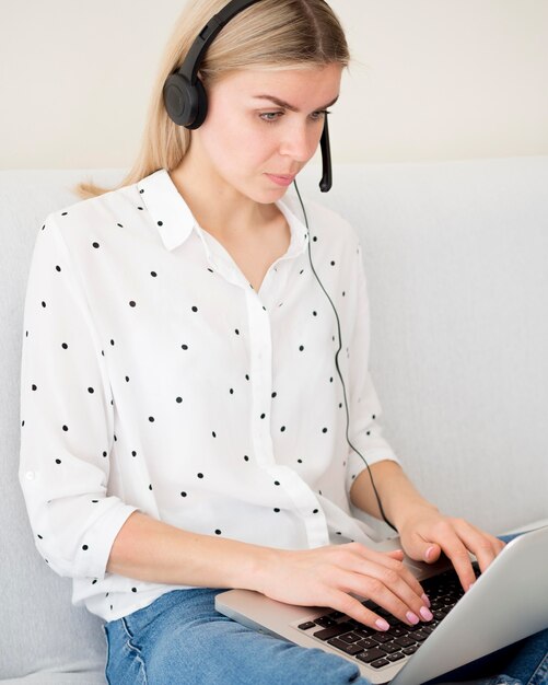 Focused woman writing on laptop e-learning concept