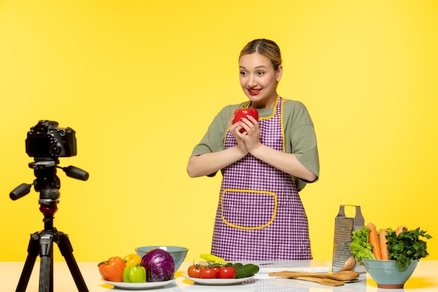 Free photo food blogger adorable healthy chef recording video for social media holding red pepper