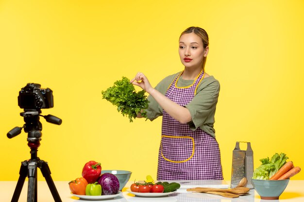 Food blogger cute fitness cook recording video for social media touching parsley