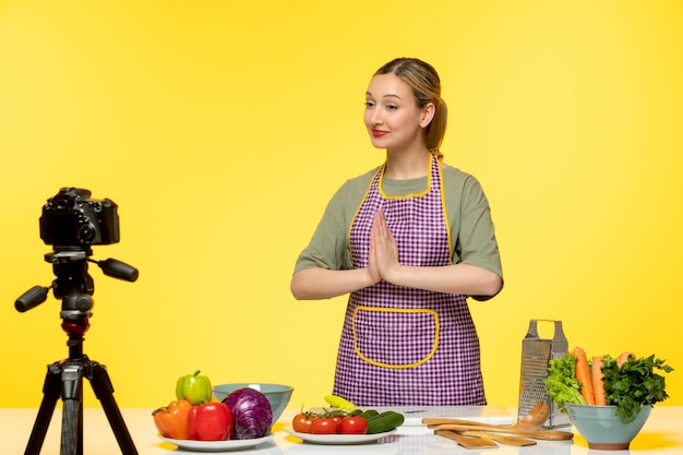 Food blogger cute healthy chef recording video for social media praying and smiling