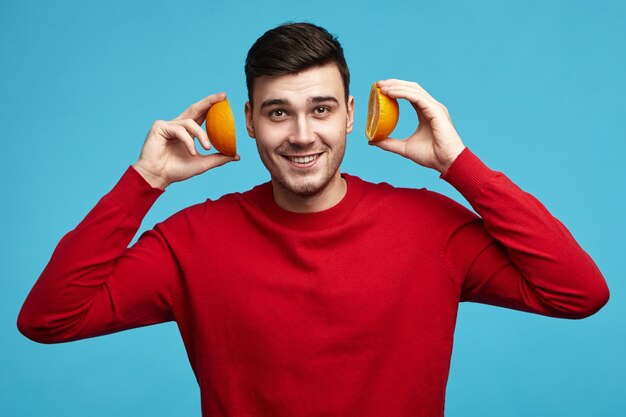 Food, energy and wellbeing concept. Portrait of positive handsome young dark haired guy