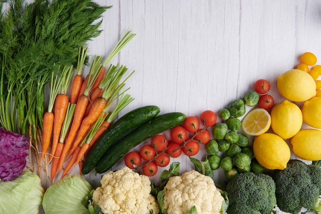 Food photography different fruits and vegetables on white wooden table surface.