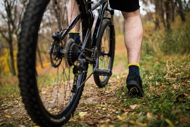 Foot on pedal of bicycle in park, active summer. Close up.