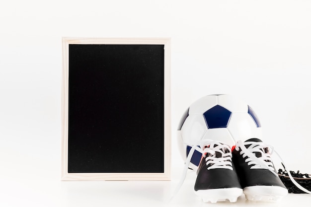 Free photo football composition with leaning slate and shoes