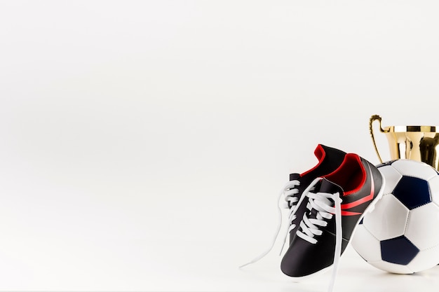 Football composition with shoes and ball next to copyspace