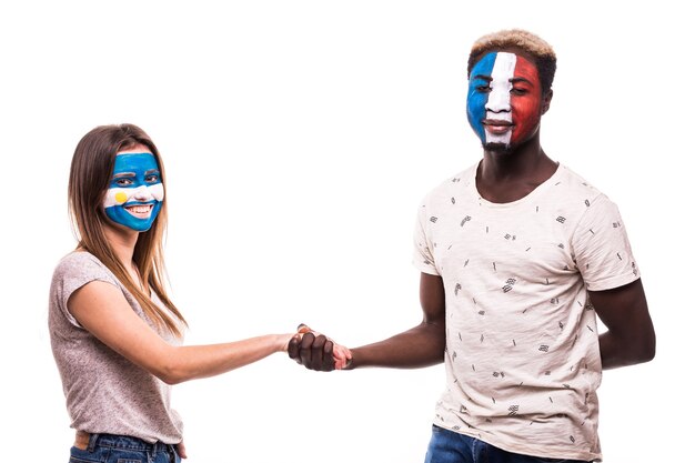 Football fans of Argentina and France national teams with painted face shake hands over white background