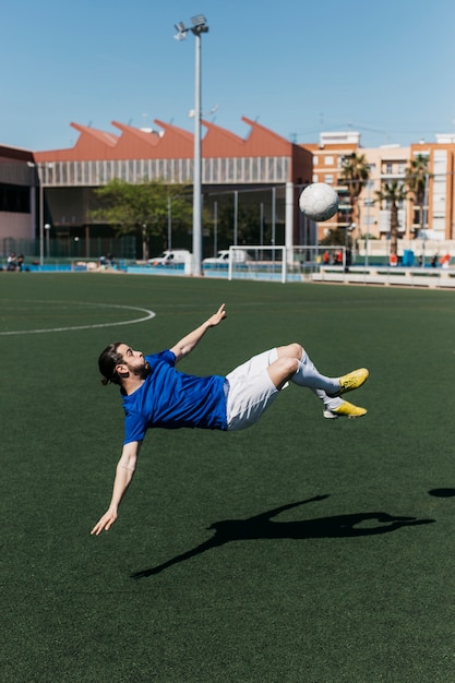 Free photo football player doing bicycle kick