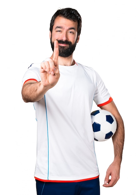 Free photo football player holding a soccer ball counting one