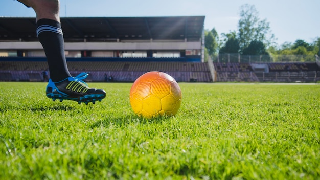 Football player kicking ball leg view