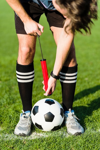 Football player pumping soccer ball