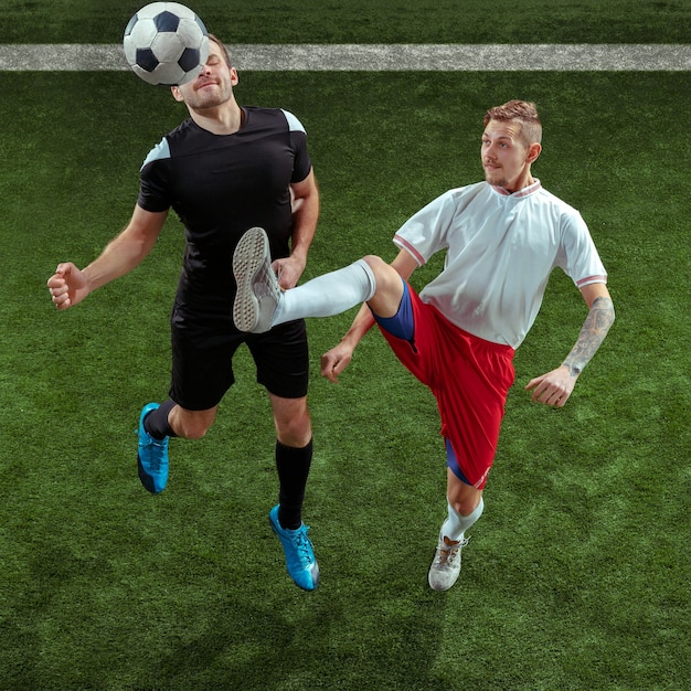 Free photo football player tackling for ball over green grass