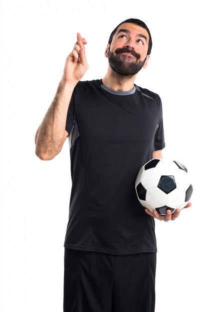 Football player with his fingers crossing