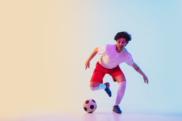 Football or soccer player on gradient in neon light