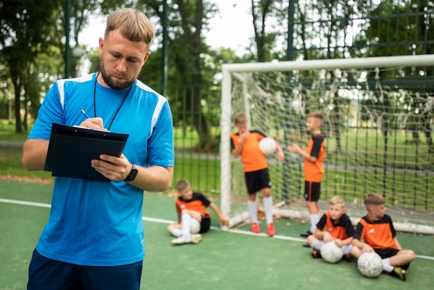 Free photo football trainer teaching his pupils