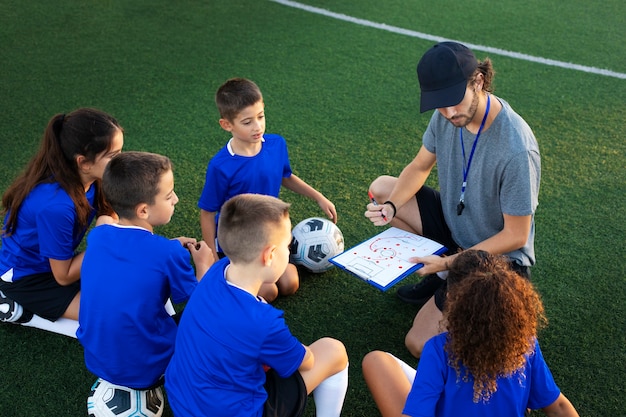 Football trainer teaching kids  high angle