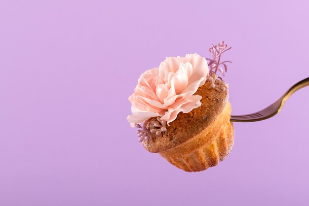 Fork holding cupcake with flower