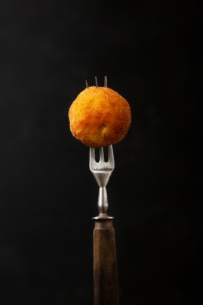 Fork holding food croquette