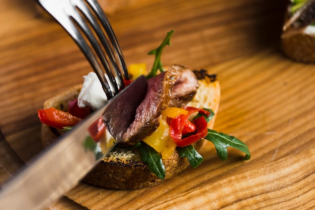 Fork and knife cutting tartine