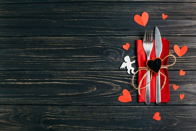 Fork and knife on napkin with paper hearts 