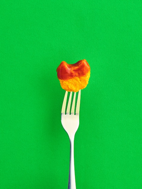 Free photo fork with a potato covered in tomato sauce