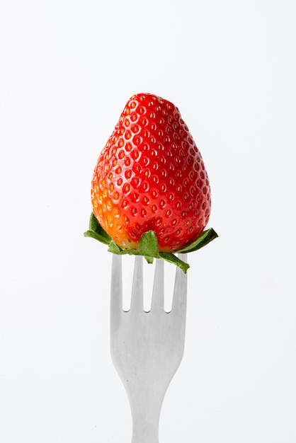 Fork with strawberry and white background