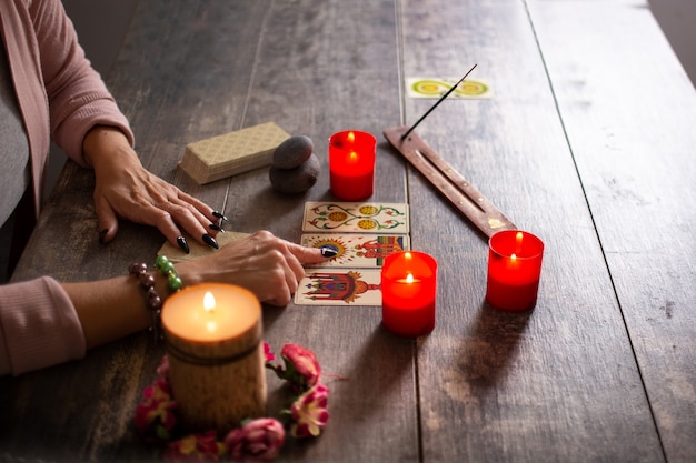 Fortune teller reading a future by tarot cards on rustic table