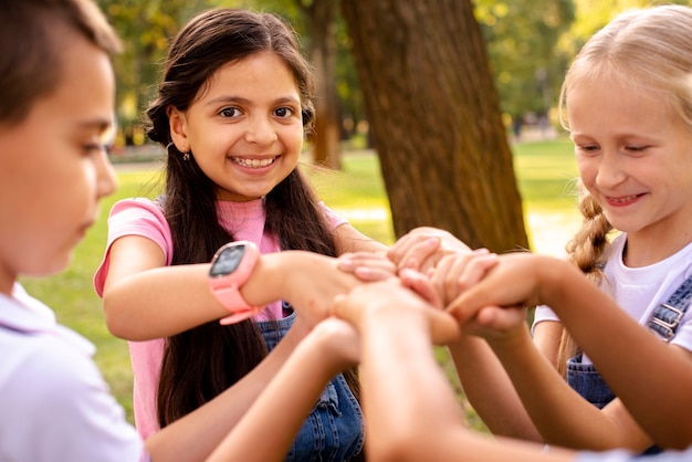 Free Photo four children holding by hands in park