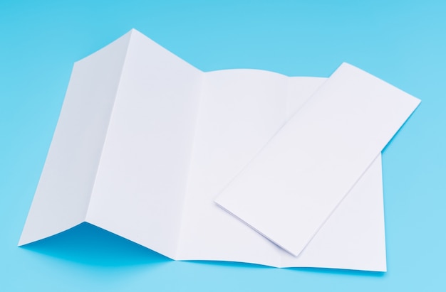 Free photo four- fold white template paper on blue background .