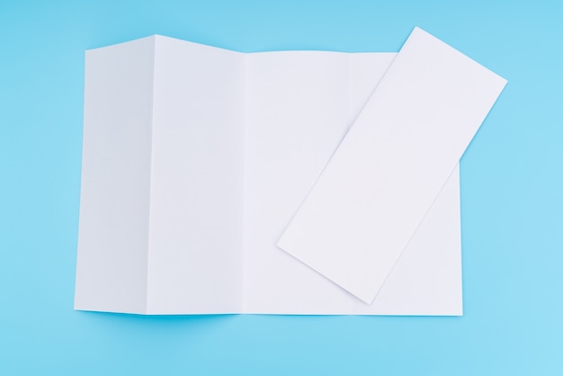 Four- fold white template paper on blue background .