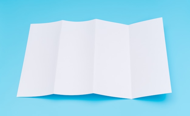 Free Photo four- fold white template paper on blue background .