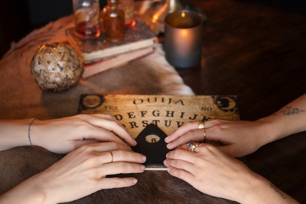 Four hands using ouija board high angle